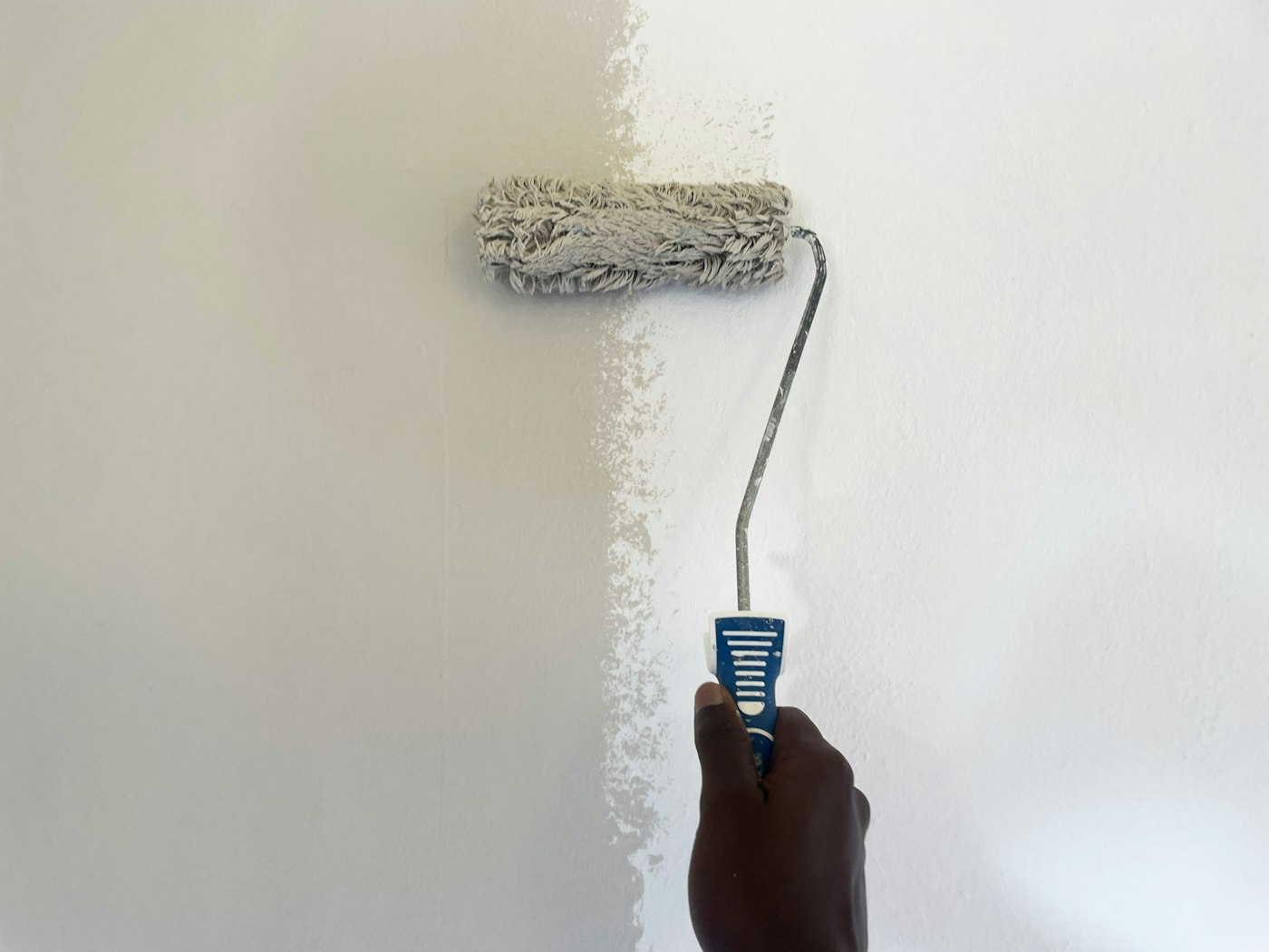 A tenant keeping their place up — rolling a fresh coat of paint